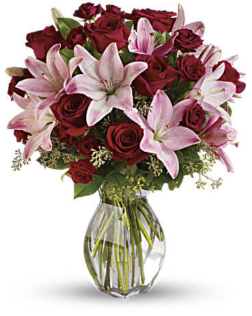 Lavish Love elegant bouquet of red roses and pink lilies in a clear vase for romantic occasions.